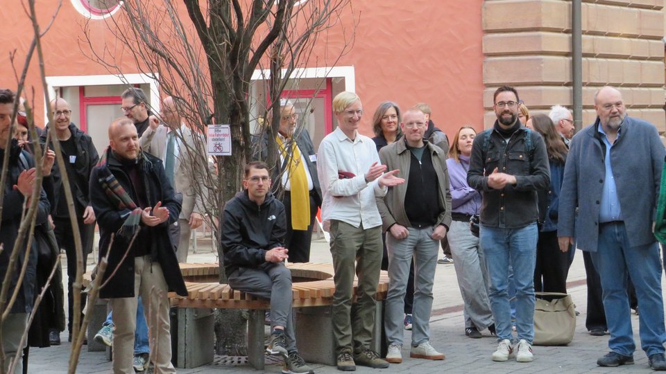 Gruppe Personen im Innenhof der Hochschule applaudierend