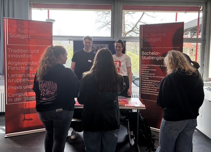 Schülerinnen informieren sich an einem Informationsstand der HFT Stuttgart