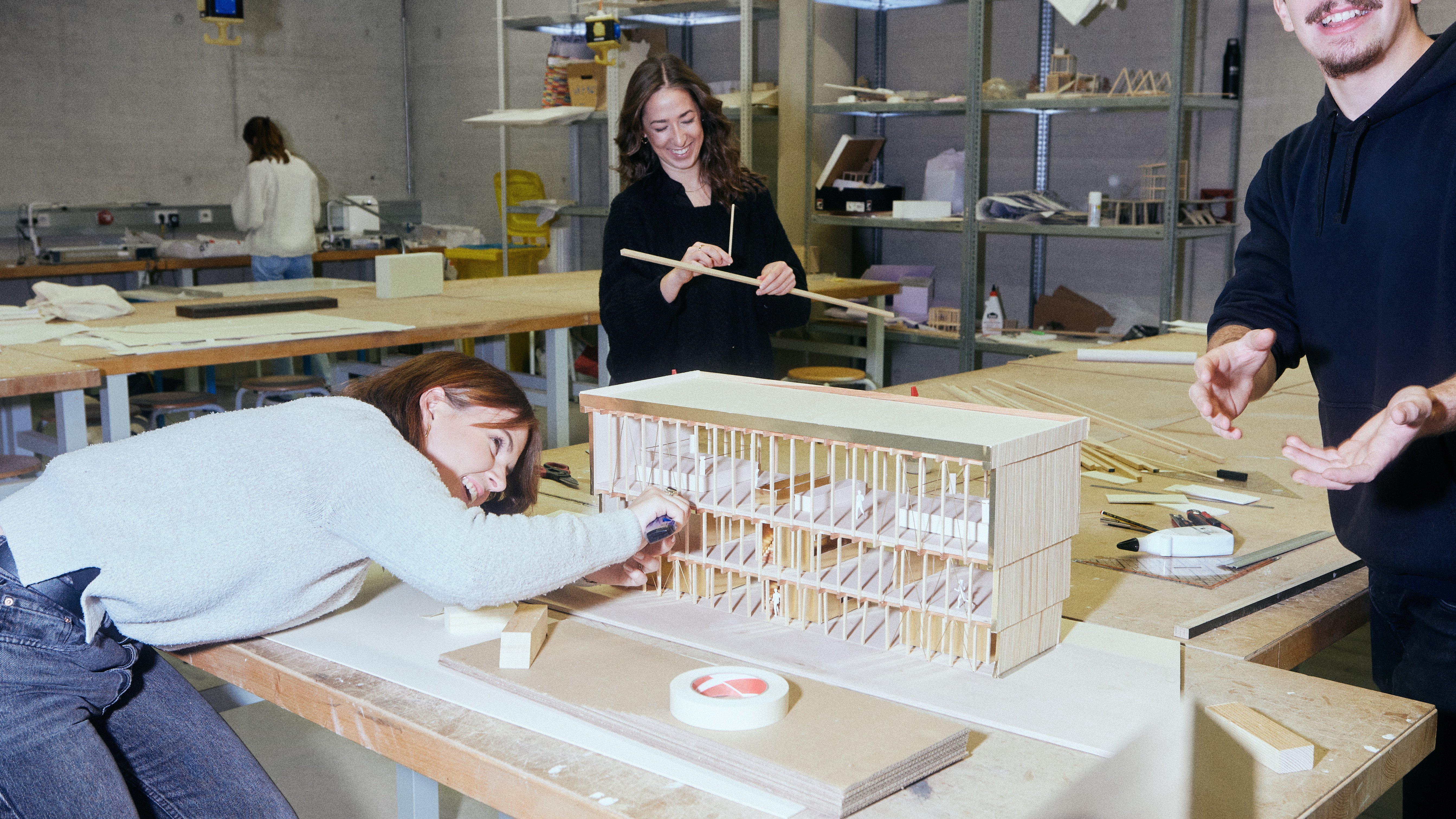 Drei Studierende bauen an einem Architektur-Modell