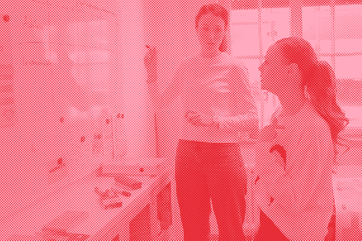The photo shows a blurred image of an advisor and a student standing in front of a whiteboard and filling in a table.