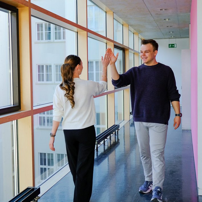 A male and female student giving each other a ‘high five’