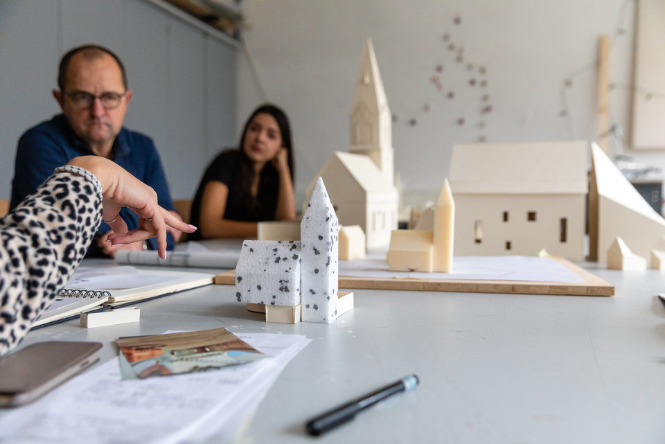 Eine Studentin zeigt auf ein Modell einer Kirche