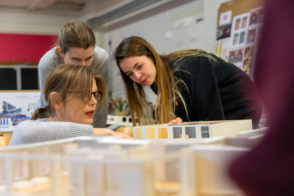 Drei Studentinnen besprechen ein Modell