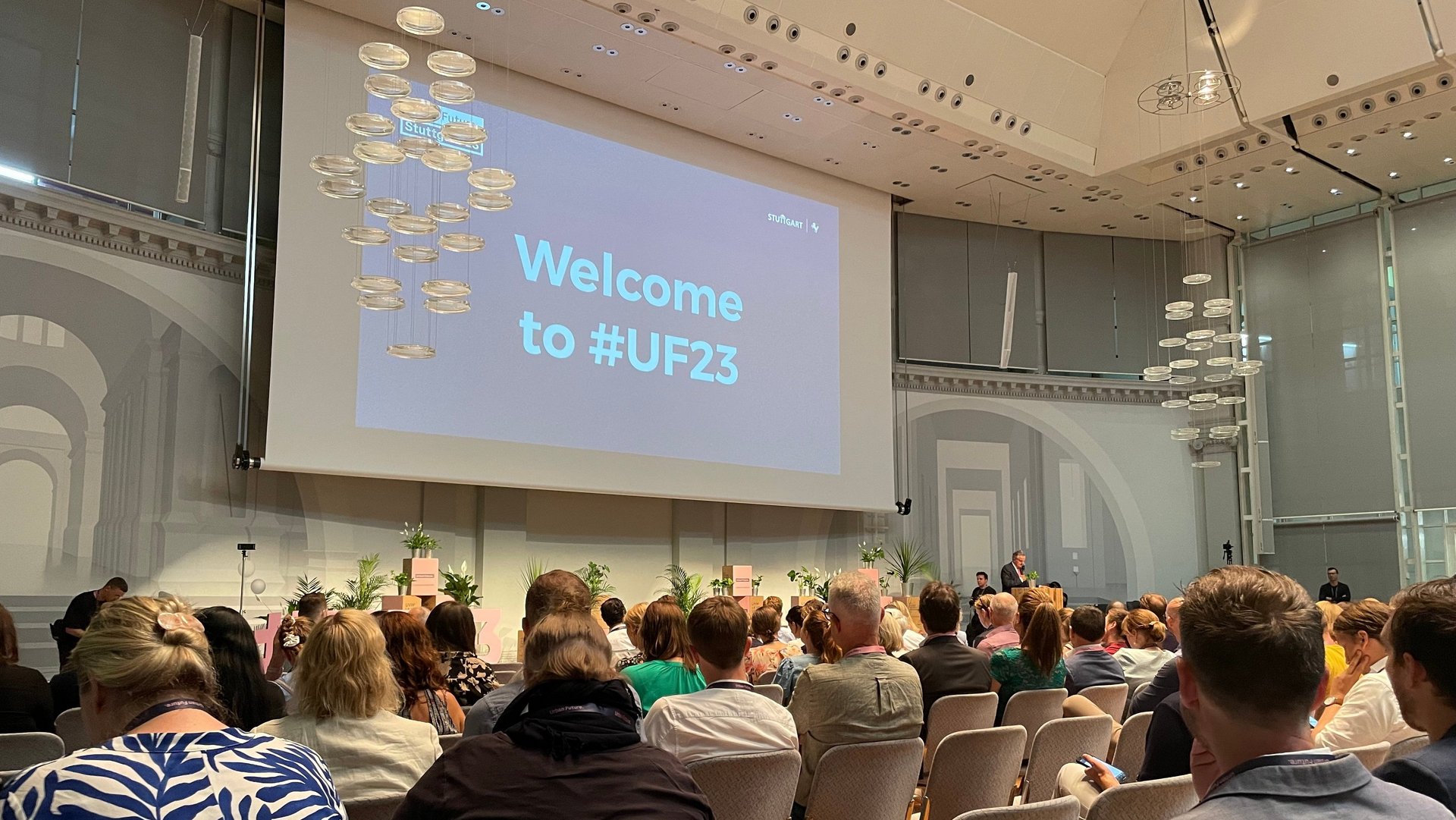 Konferenzteilnehmerinnen und -teilnehmer sitzen im Veranstaltungssaal.