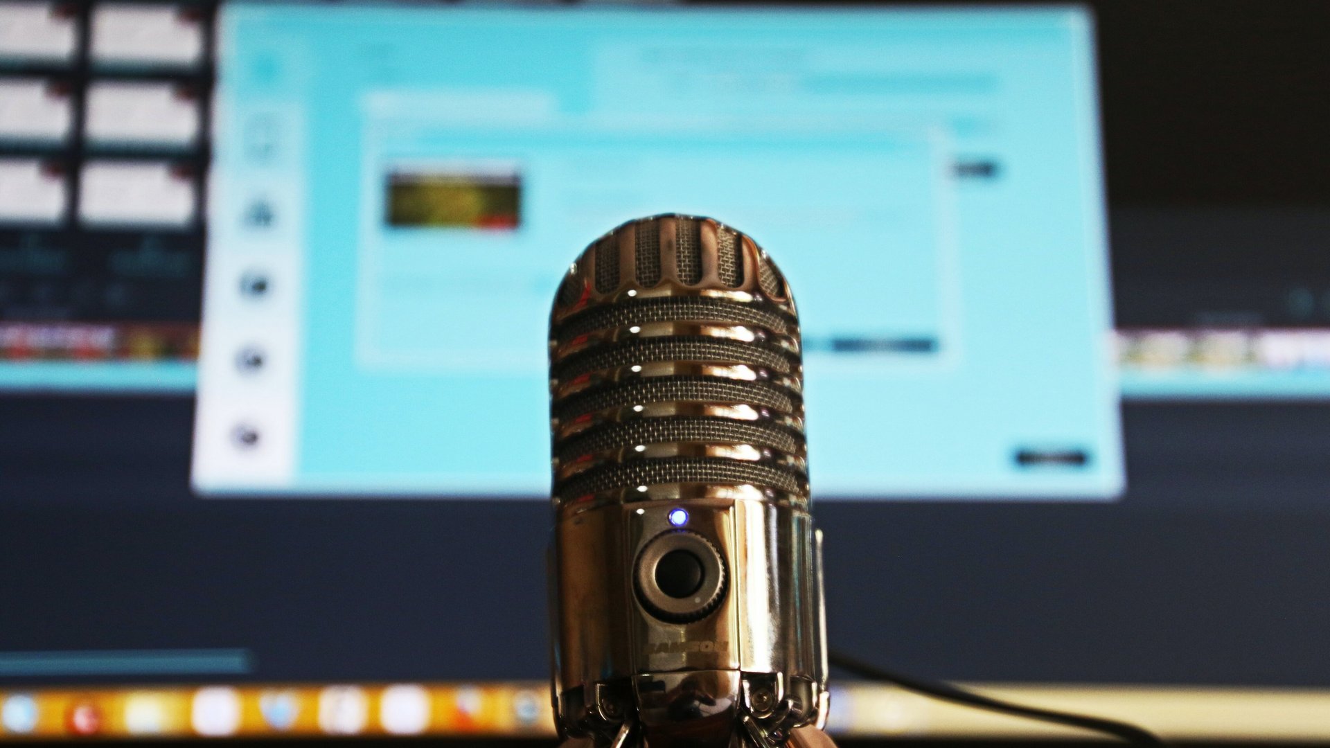 Podcast-Mikrophon vor einem Monitor 