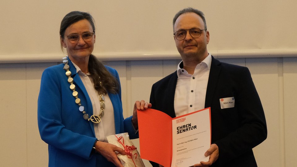 Urkundenübergabe an Björn Riker durch Rektorin Katja Rade