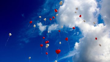 Lufballons fligen in den blauen Himmel