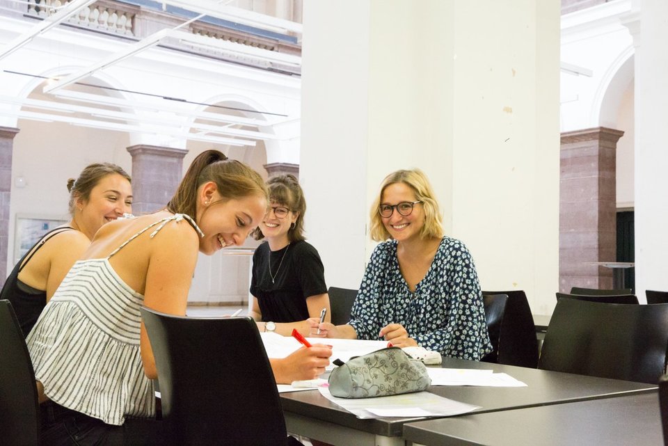 Vier Studierende sitzen am Tisch zusammen