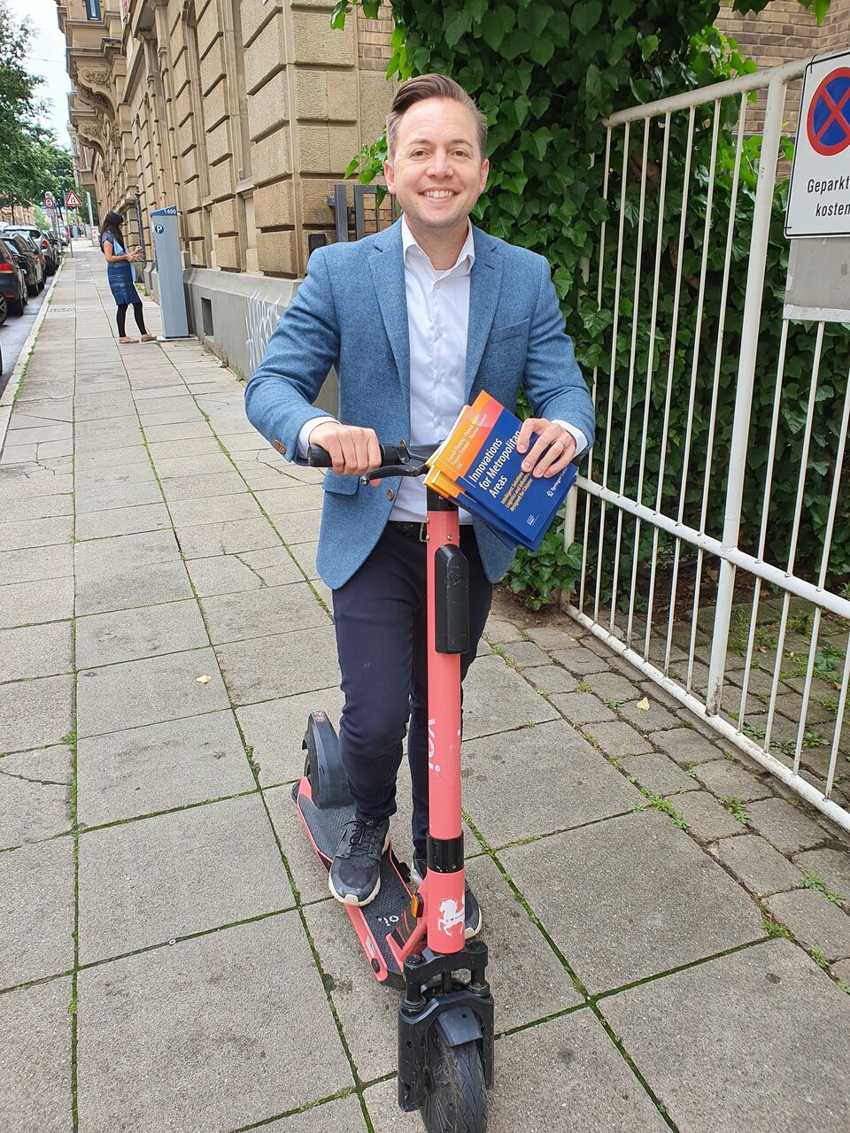 Professor mit Buch auf Roller