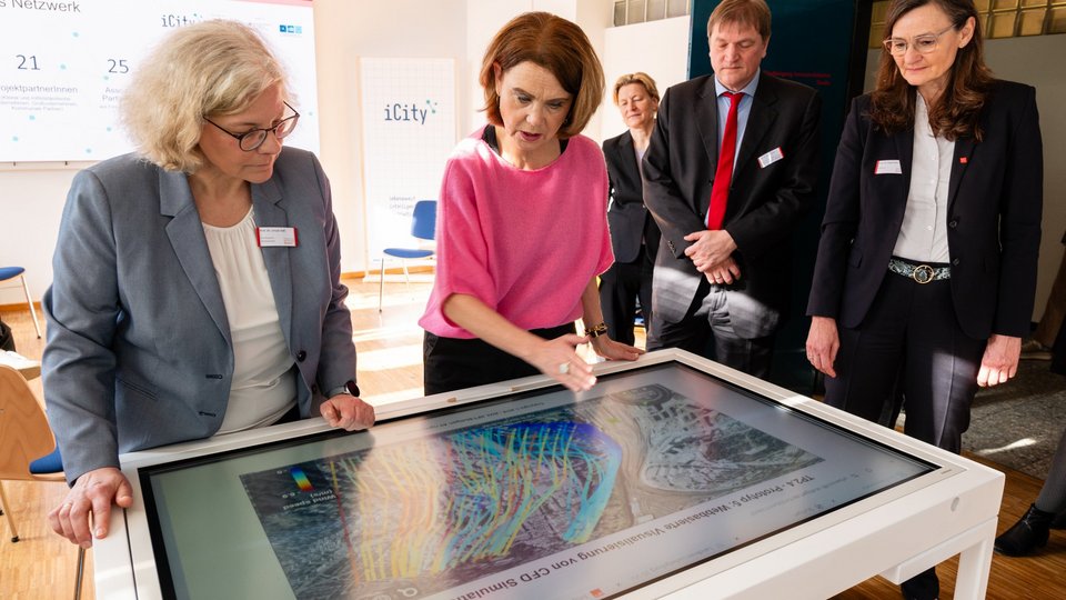 Mathematik-Professorin Prof. Dr. Ursula Voss (1.v.l.) erläutert der Wissenschaftsministerin Petra Olschowski (2.v.l.) die Simulation urbaner Windströmungen bei deren Besuch an der Hochschule für Technik Stuttgart. 