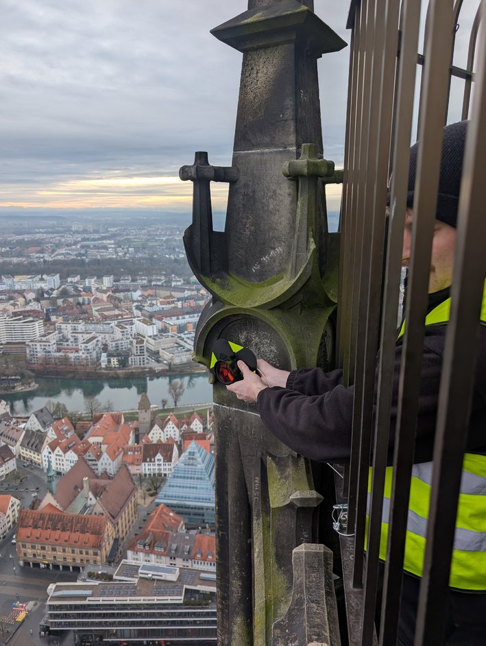 Überwachungsvermessung am Ulmer Münster: Ausrichten eines Reflektors am Turm