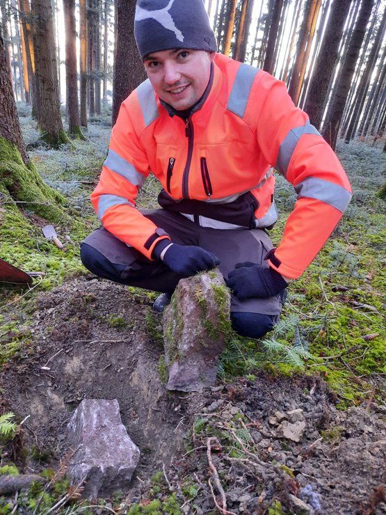 Student bei der Suche nach Waldgrenzsteinen während seines Praxissemesters