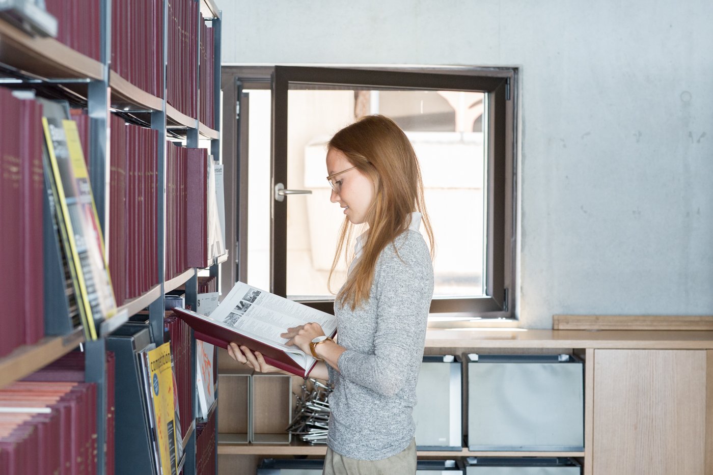 Studentin liest ein Buch in der Bibliothek